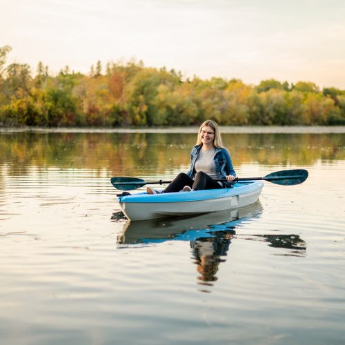 Woman kayaking on a river in fall