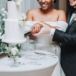 Bride and Groom cutting a two tiered white cake