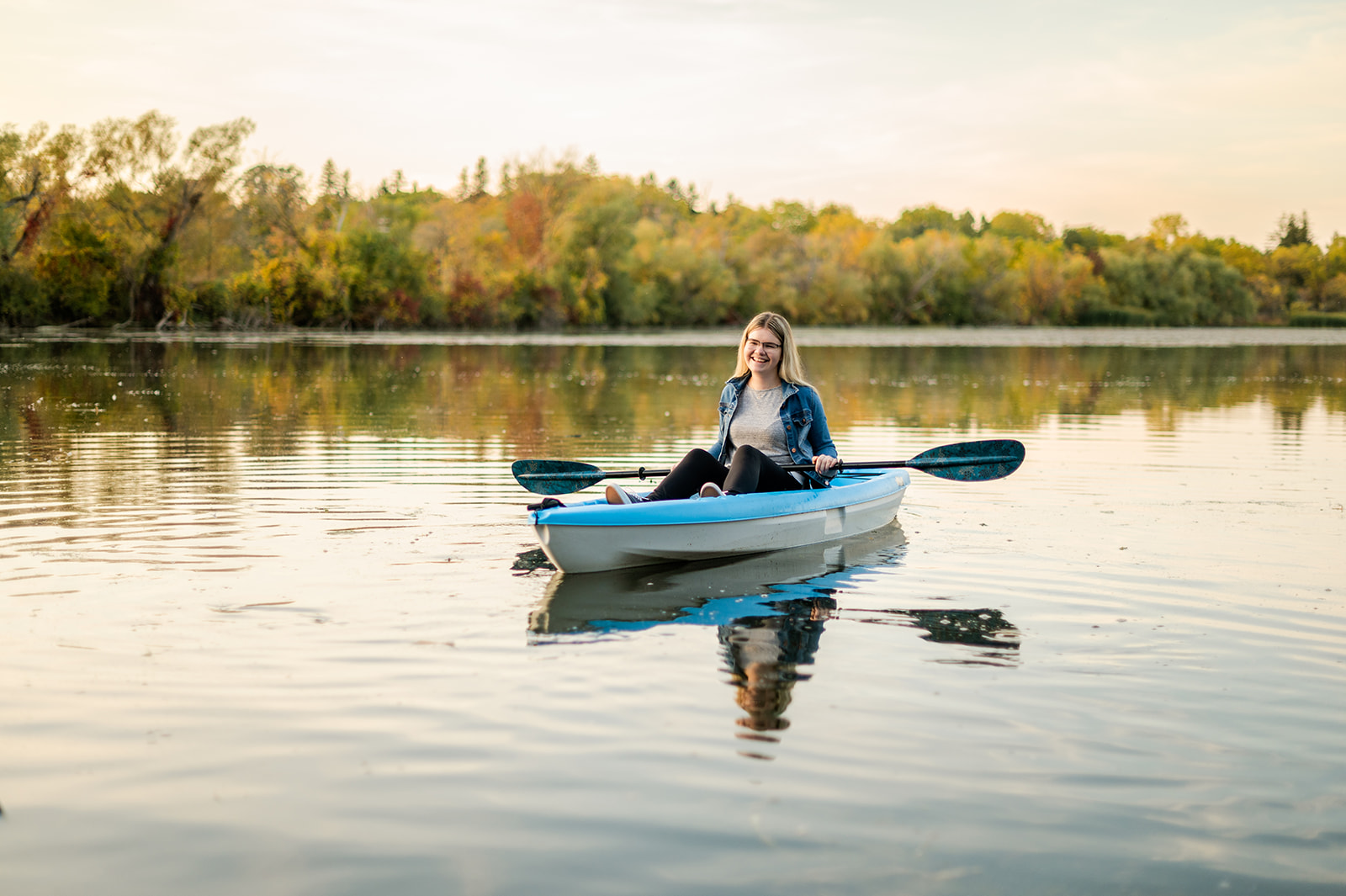 Katelyn kayaking on a river in fall