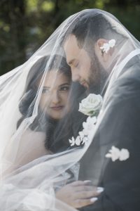 Couple on their wedding day underneath veil